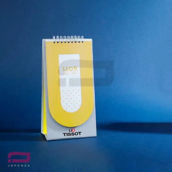 تقویم رومیزی R1121R با طراحی عمودی، جلد زرد مینیمال و حک لوگوی برند تیسوت Tissot